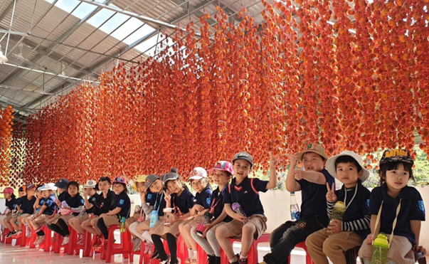 Children sitting under hanging decorations